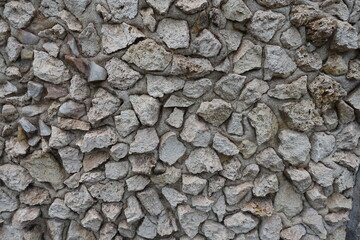 Coarse surface of wall with light gray gravel pebble dash