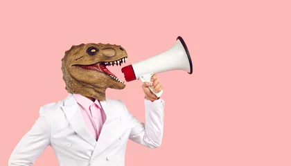 Poster Man wearing dino mask yells in megaphone, side profile view studio portrait. Funny human dinosaur in suit promotes new product, shopping event, invites to party. Scary monster fights for animal rights © Studio Romantic