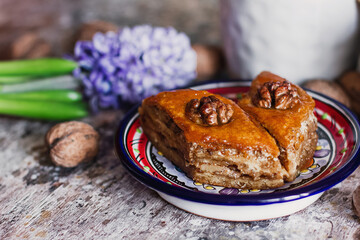 Assorted baklava. A Turkish ramadan arabic sweet dessert on a decorative plate, with coffee cup in the background. Middle eastern food baklava with nuts and honey syrup