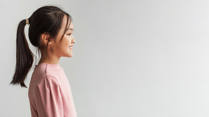 Cheerful Japanese Preteen Girl Posing Looking Aside, Gray Background