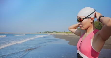woman training triathlon at beach - obrazy, fototapety, plakaty