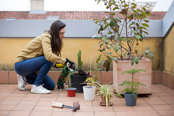 Young woman taking care of her plants. Gardening.