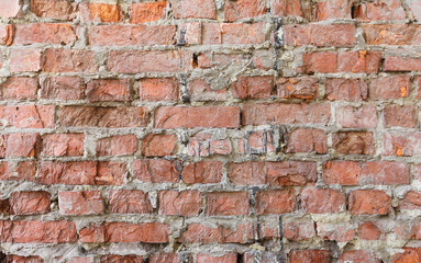 Old and weathered red brick wall close up. Vintage house facade. Abstract texture, horizontal brick tile background.