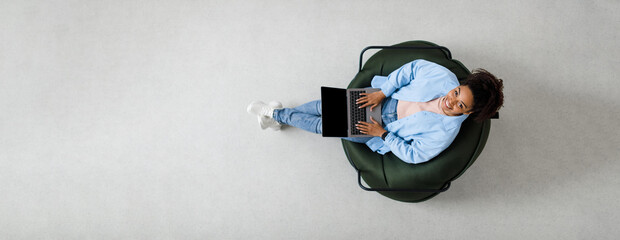 Portrait of smiling black woman using laptop at home