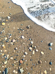 Seashore natural background in beige color palette. A beach with pebbles and wet sand.