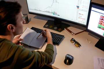Fototapeta premium Trader watch and draw business graph in notebook