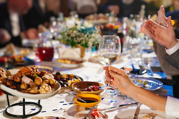 hands with glasses above the festive table