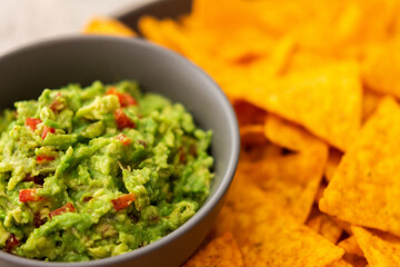 Mexican corn chips nachos with avocado red pepper sauce, top view