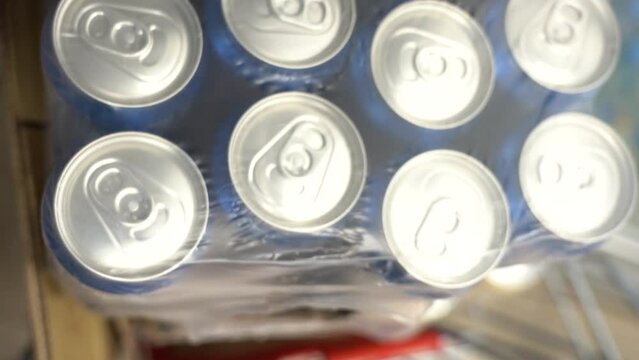 A row of beverage cans in a trolley. Unpacked beverage cans. Top view. Nobody.