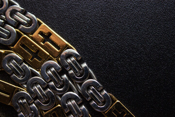 Women silver necklace with baroque pearl pendant on male black leather briefcase. Close-up shot