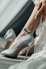 Shiny wedding shoes on the bride's legs close-up
