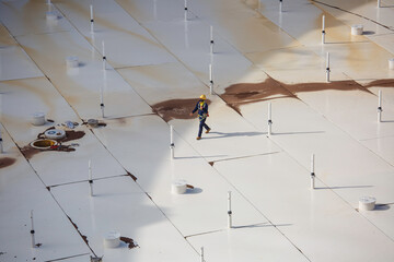 Male worker on white roof of storage crude oil