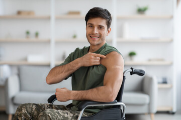 Happy disabled soldier showing band on shoulder and thumb up