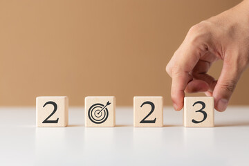 2023 new year goal planning idea, wood block cube with new year 2023 and target icon, business...