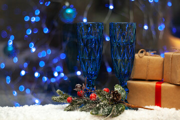 Blue glasses on the blurred background of the Christmas tree. Gifts for the New Year and Christmas.