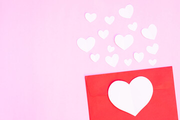 Red envelope with heart papercut on pink background