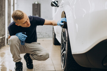 Man at car clean polishing tires
