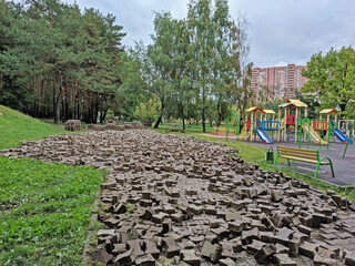 Old pavement tiles after dismantling in the city park next to the playground