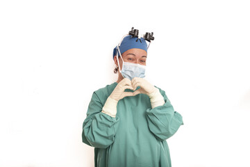 Young blonde surgeon doctor woman over isolated background smiling in love showing heart symbol and shape with hands. Romantic concept.