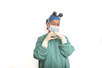 Fototapeta na wymiar Young blonde surgeon doctor woman over isolated background smiling in love showing heart symbol and shape with hands. Romantic concept.