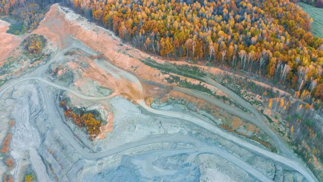 A large clay pit for the production of bricks, with a clean lake in the middle of a beautiful autumn forest in Ukraine. Aerial photo drone copter photo from a bird's eye view.