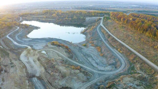 A large clay pit for the production of bricks, with a clean lake in the middle of a beautiful autumn forest in Ukraine. Aerial photo drone copter photo from a bird's eye view.