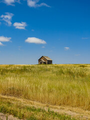 Old Wooden Pioneer House Abandoned on the Prairie Hillside
