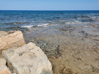 Fototapeta na wymiar Protaras. Famagusta area. Cyprus. Large stones on the shores of the Mediterranean Sea, clear sea water and a cloudless sky.