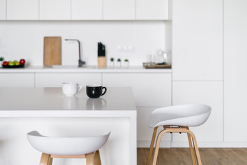 Fototapeta na wymiar White tones kitchen interior design with stylish bar chairs