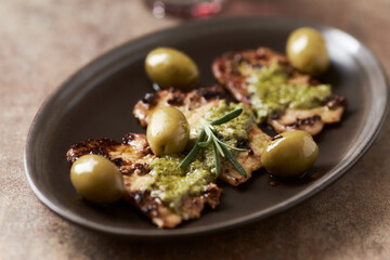 Fried pork with green olives and fresh rosemary. Close up.