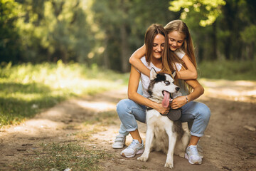 Two sisters with their dog in park