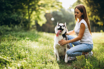 Naklejka na ściany i meble Girl with her dog in park