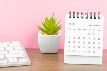 September 2022 desk calendar with plant on wooden table. - obrazy, fototapety, plakaty