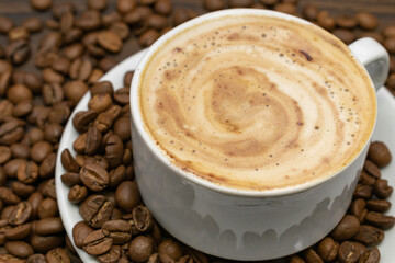 White cup of coffee with roasted beans. cup of cappuccino