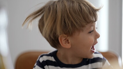 One child shakes head and hair being goofy and fun - obrazy, fototapety, plakaty
