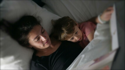 Mother telling bedtime story to toddler mom holding book night routine