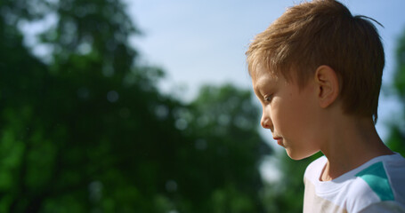 Concentrated boy play football closeup. Active kid training soccer uotdoors.