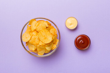 Top view chips with sause in bowl on colored background, top view with copy space