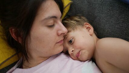 Mother and child lying on sofa resting little boy lies on couch with mom