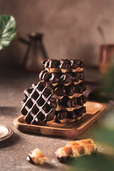 Stack of chocolate wafers on table on brown background