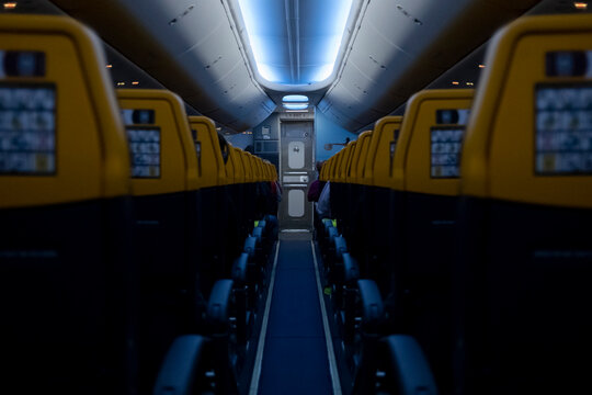 Interno aereo commerciale, vista corridoio, con due file di sedili sulle navate