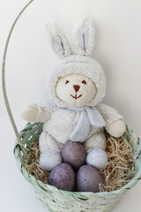 Easter bunny in a basket with colored eggs