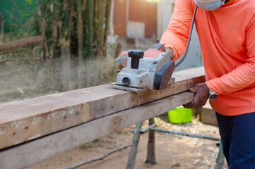 Carpenter, electric wood sharpener, carpenter's hand and electric wood sharpener.