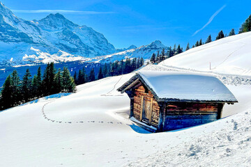 Spuren im Schnee zu einer einsamen Hütte