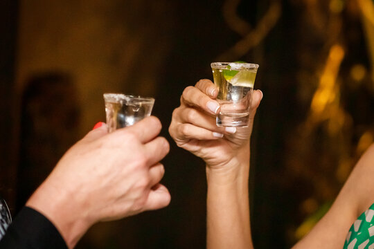 Garotas fazendo um brinde com doses de tequila