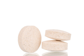 Three medical tablets, macro, isolated on a white background.