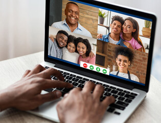 Fototapeta na wymiar Electronic communication. Young black guy having group video conference with his family, speaking to relatives online