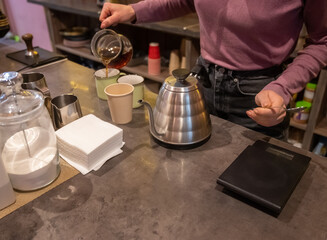 Fototapeta na wymiar Woman barista making drip coffee