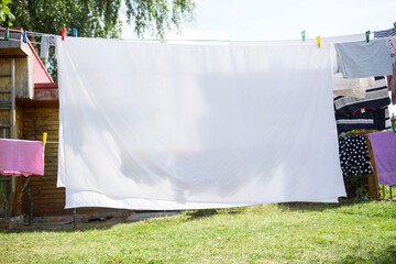 wet laundry dries outside in sun in village in summer