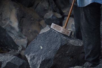 close up of a metal hammer and a volcanic rock